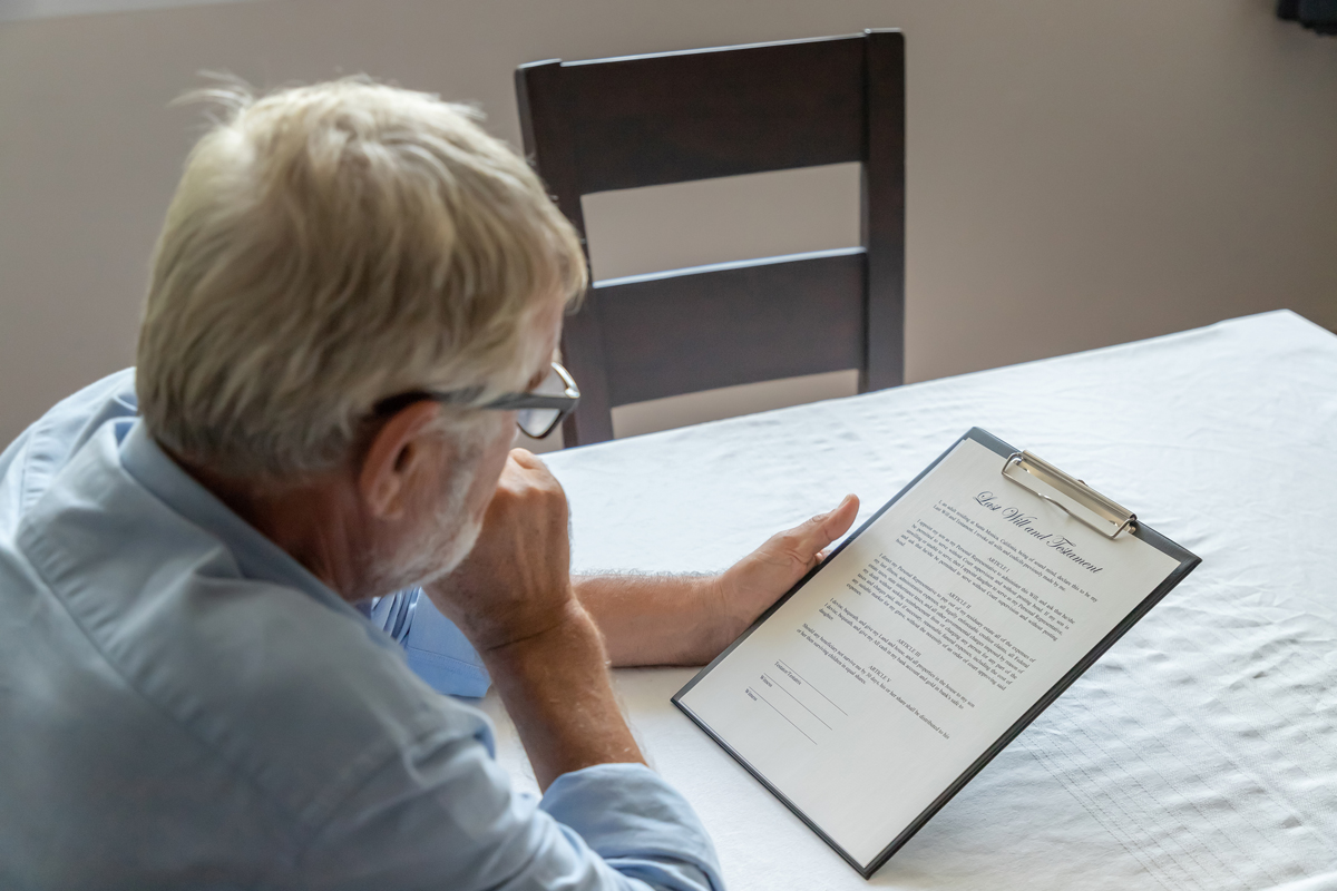 Senior-old-man-elderly-examining-and-checking-last-will-and-testament-stock-photo